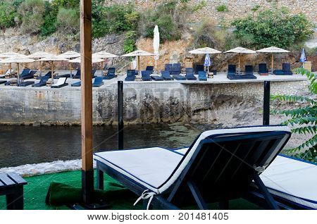 ULCINJ, MONTENEGRO - JULY 30, 2017: Small rock beach Liman on the Adriatic Sea in Ulcinj, Montenegro. Early morning time with empty beach beds, closed umbrellas and without people.