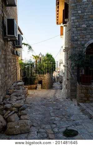 ULCINJ, MONTENEGRO - AUGUST 1, 2017: Old narrow street in Stari Grad of Ulcinj, Montenegro. The fortress in the Old town in a sunny summer day.