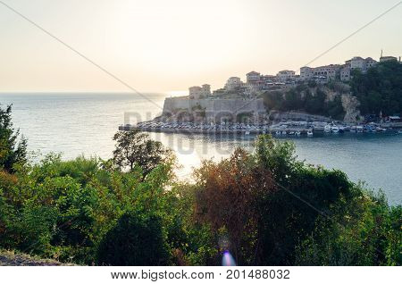 Beautiful sunset view on sea and Stadi Grad - old town of Ulcinj at twilight scene. Coast of Adriatic sea. Montenegro.