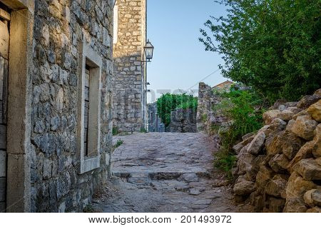Old narrow street in Stari Grad of Ulcinj Montenegro. The fortress in the Old town in a sunny summer day.