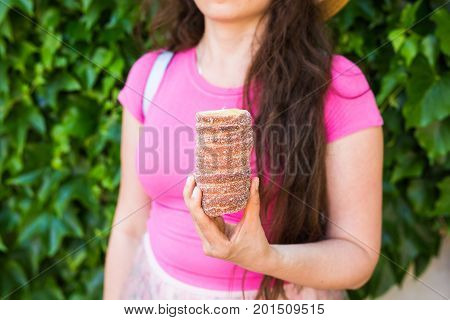 Close-up of young female tourist with traditional czech dessert trdelnik in Prague. Czech Republic. Outdoor.