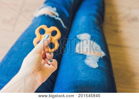 Girl Teenager In Holey Jeans Holds In Hands And Plays With Spinner