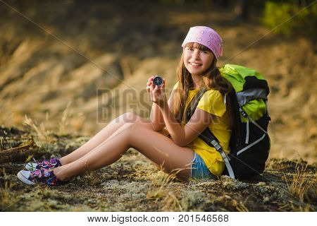 Teen girl traveler with backpack holdind compass. Travel and tourism concept.