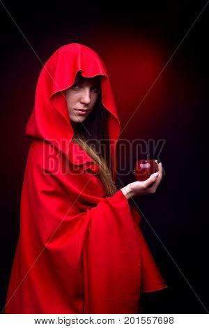 beautiful woman with red cloack holding red apple