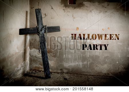 Black cross against the wall with hanging steel chain Halloween party festival posture advertising. Halloween's Day and ghost concept. Dark and scary tone tone pinterest and instragram like process.