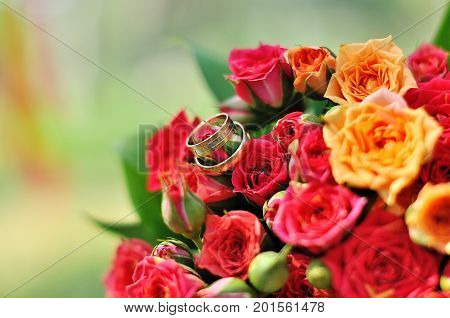 two golden wedding rings on floral background