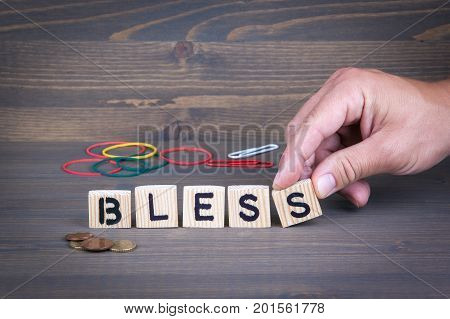 Bless. Wooden letters on dark texture background