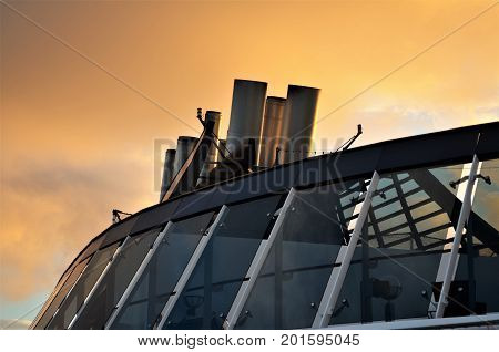 Cruise ship chimneys in contrast to the colorful sky in the sunset.