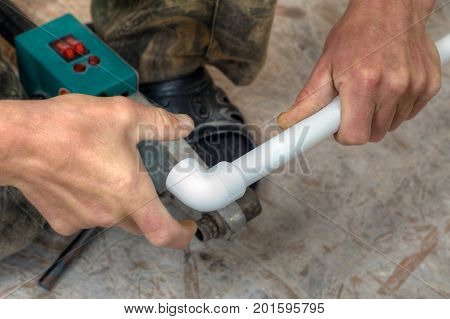 Polypropylene pipes welding hands working close up.