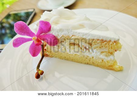 The coconut cake with coconut meat with orchids Pink on white plate.