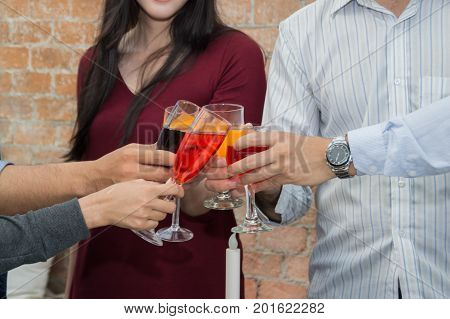 Young people holding glass talk in the party.