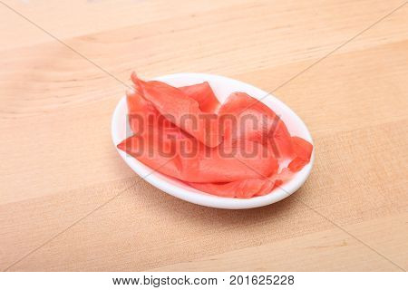 plate with Japanese pickled ginge on wood background