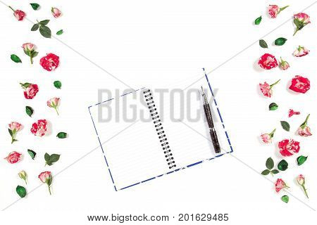 Open paper notebook and rose flowers frame. Flat lay, top view