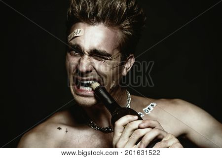 Antisocial behavior, bad habits. Portrait of a bad boy smoking cigarette. Rocker, punk.