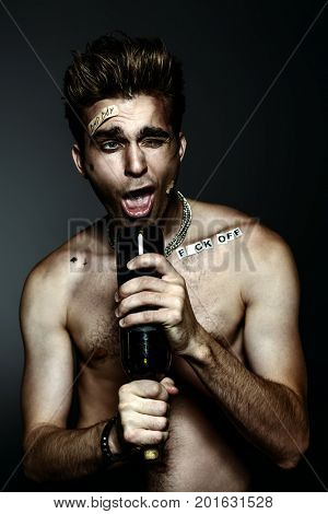 Antisocial behavior, bad habits. Portrait of a bad boy smoking cigarette. Rocker, punk.