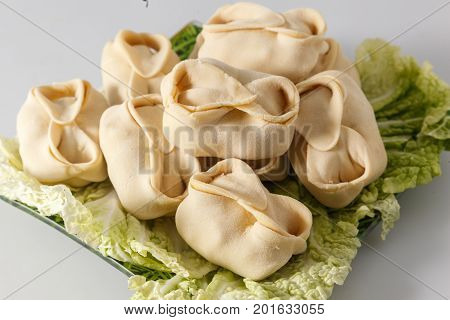 Frozen Dumplings On The White Plate With Green