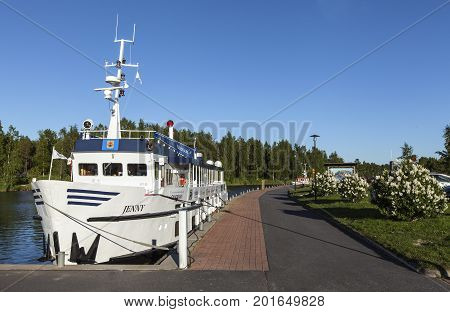 KOKKOLA, FINLAND ON JULY 07. View of M/S Jenny moored by the port on July 07, 2017 in Kokkola, Finland. Channel, sidewalk and bushes in the surrounding. Editorial use.