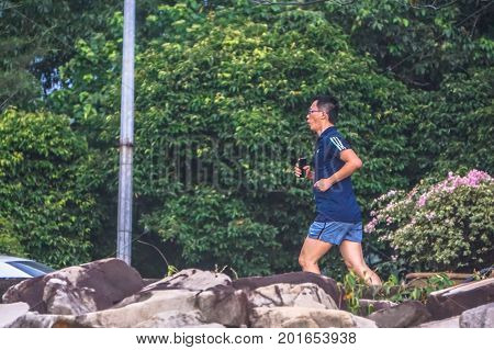 Kota Kinabalu,Sabah,Malaysia-Aug 8,2017:Healthy active man jogging in a park in the evening at Likas,Kota KInabalu,Sabah,Malaysia.