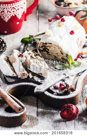 Christmas stollen, traditional German, European festive dessert cut into pieces on wooden background.