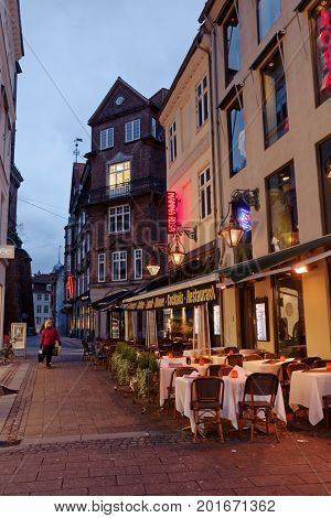 COPENHAGEN, DENMARK - NOVEMBER 6, 2016: People at the street terrace of the restaurant Mamma Rosa in evening. It is one of the oldest restaurant on pedestrian street Stroget