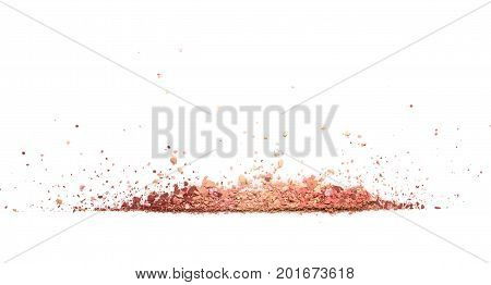 Samples of dry blush, powder, bronzers and highlighter scattered in line isolated on white background