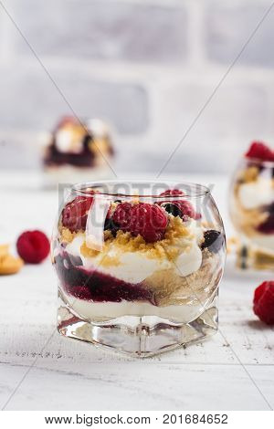Homemade dessert in glass jars. Cheesecake, trifle, mouse on white wooden background. Copy space