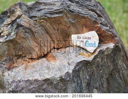 A decorated rock was left on an old tree stump at a city park as a reminder to be close to God.