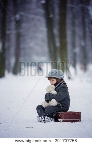 Sad Child, Boy, Walking In A Forest With Old Suitcase And Teddy Bear