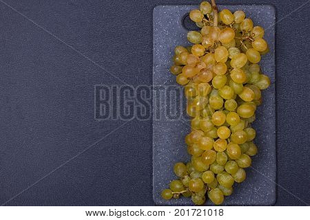 fresh delicious and healthy organic concord grapes on cutting board. copy-space