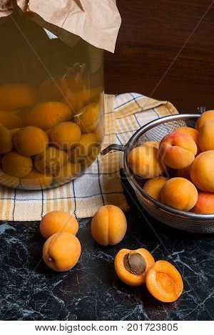 Fresh Organic Harvested Apricots In Steel Colander And Big Glass Jar With Canned Apricot Compote On
