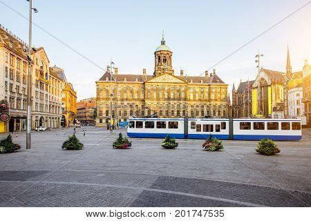 Morning view on the Dam square with Royal palace and tram in Amsterdam city during the sunny weather