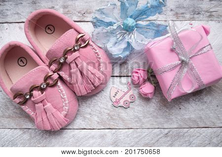 Close up of baby shoes on a wood background. Greeting card