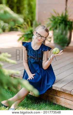 Adorable little school girl with notes and pencils outdoor.