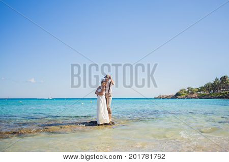 Cheerful married couple standing on the beach.