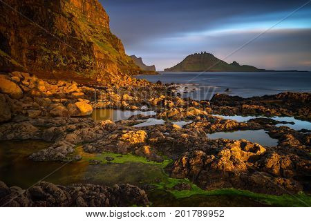 Gasadalur rocky harbour with Tindholmur island in sunset Faroe Islands