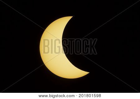 The sun with a prominent group of sunspots on the left side is about half-way covered by the moon during the total solar eclipse in August 2017.