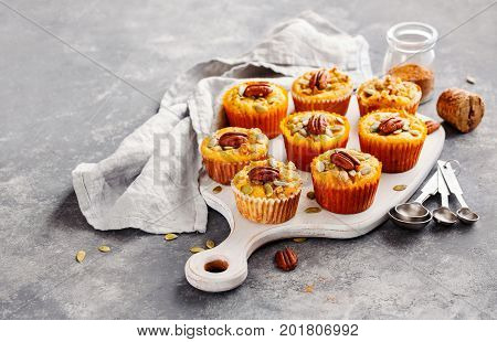 Freshly baked pumpkin muffins with pecans selective focus.