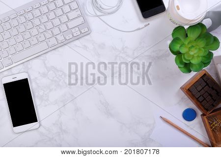 Smartphone Kayboard and office supplies on marble background