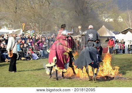 06.04.2015 Lorelay Germany - Medieval games knight armor on the horse riding through flame during tournament reconstruction