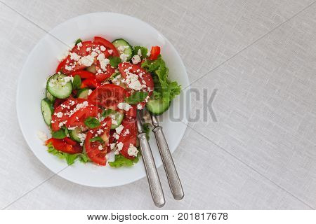 Shopska Salad In A White Plate On A White Tablecloth. The Concept Of Minimalism
