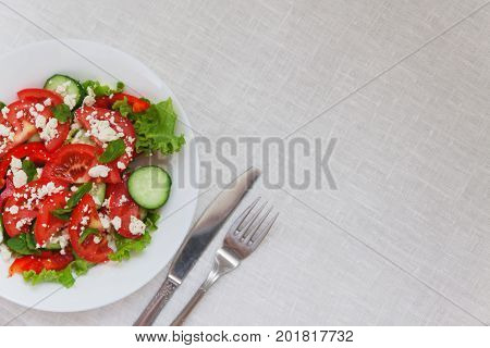 Shopska Salad In A White Plate On A White Tablecloth. The Concept Of Minimalism