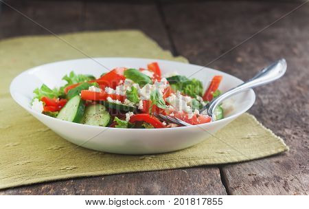 Shopska Salad In A White Plate On A Wooden Background, Close-up