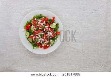 Shopska Salad In A White Plate On A White Tablecloth. The Concept Of Minimalism