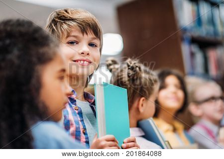 adorable little kids with books in school library