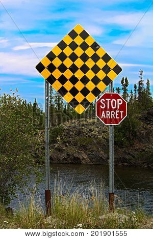 A checkered no entry and stop sign in both english and french.