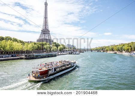Landscpae view on the Eiffel tower and Seine river with tourist boat in Paris