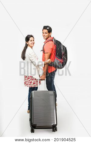 stock photo of smart Asian or Indian couple traveler with suitcase and hike bag isolated over white background, going abroad or within country, perfect shot for tours and travels company