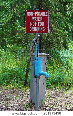 A non-potable water not for drinking sign near a pump.