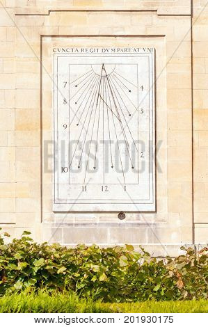 Antique sun clock on the wall of medieval castle, France