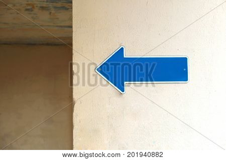 a pointer to the name of the street a sign on the wall of the building on the street